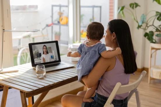 An adult holding a baby while having a video call